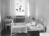 Interiör barnsjukhuset i Linköping. Lasse sitter i sin säng i barnrummet juni 1931. Bilder från Barnsjukhusets invigning i Linköping. Invigningen av Blåklintshemmet år 1931. Bilder från Blåklintshemmets invigning år 1931.