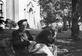 Män på bänk utanför kyrkan, 1960-tal
