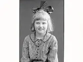 Flickporträtt. Järnhandlare Arvid Ekströms dotter Harriet i smårutig klänning och en stor rosett i håret.