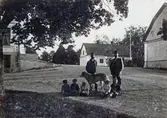 Grupp på gårdsplanen vid Karlslunds gård, 1890-tal