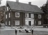 Familj utanför kvarnmästarbostaden på Karlslunds gård, 1890-tal