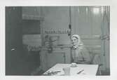 Hilda Sandberg (1887-1973, född Olsson) sitter i sitt kök, 
