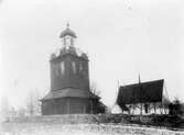 Grundsunda kyrka. Klockstapeln byggdes 1794 av Lars Pettersson-Grundström. Den är klädd med panel och takpartierna täcks av spån.