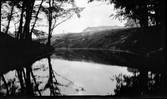 Den inre vallgraven vid Rumlaborg i Huskvarna är åter vattenfylld. Foto taget i samband med arkeologiska undersökningar vid borgen sommaren 1932. I samband med undersökningarna hade vallgraven tömts på vatten med hjälp av en elektriskt driven pump, en spåntvägg hade även anlagts tvärs över vallgraven mot Huskvarnaån.