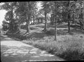 Rumlaborg i Huskvarna med lusthuset på toppen. Till vänster syns den gamla landsvägen. Fotot är taget i samband med arkeologiska undersökningar vid borgen sommaren 1938.