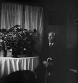 Man i hemmiljö omgiven av blommor, Brillinge, Uppsala