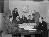 Män sitter vid bord och tittar på byggmodell, Uppsala 1949
