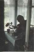 Hilda Sandberg (1887-1973, född Olsson) häller upp kaffe inne på verandan, 