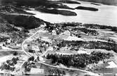 Flygfoto över Dal. Mörtsjön i bildens framkant. I bildens övre vänstra hörn skymtar Ramvik och till höger om detta Västby och Gustavsvik.