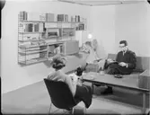 KALKAD EK, UPPSTÄLLNING I VÄLLINGBY (FAMILJEINTERIÖR)
INT.