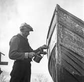 Bordskrapning av färg på träbåt, 1946-02-26