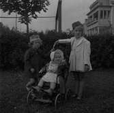De tre yngsta av fem systrar med efternamnet Röös. Till vänster Kristina född 1939, i vagnen Agneta 1942, och  Birgit 1937 iklädd båtmössa och ljusblå kjol med små blommor. 