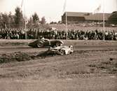 Moss passerar Bonniers bilvrak. Gelleråsen, Karlskoga. 1958-08-10