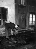 Man dricker från vattenpump., 1950-1958