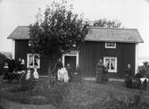 Familj framför hus i Bengtstorp i Viker 1889