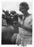 Kvinna med bilolja i burk, 1924
