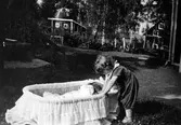 Barn vaggar småsyskon på Bomanshyttan i Nora, 1930-tal
