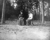 Kvinor sittande på bänk, ca 1905