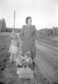 Barn och kvinna väntar på bussen i Stora Mellösa, 1930-tal