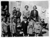 Grupp vid husvägg på Olaigatan, 1940-tal