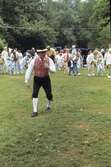 Barn och vuxna dansar kring stången vid midsommarfirande på Ekensås cirka 1982. Lekledare är Sven Olof 