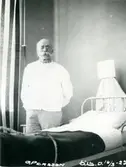 Äldre man vid sjukhussäng, 1922