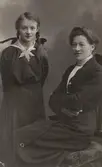 Sittande kvinna och flicka med flätor, 1910-tal