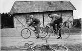 Cyklister vid tegelbyggnad, 1930-tal