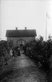 Familj framför hus, 1910-tal