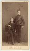 Man i uniform och en pojke, efter 1880