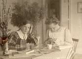 Två systrar vid köksbordet, 1907