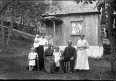 Gamla Dala (Dalen) i Sällstorp, torp under St Råryd. Torpet revs 1931. Här är familjen Johansson samlad framför vävstugan, fr v: Vera, Tilda (med flickan på armen), Johanna-Britta och August Johansson sitter med Melan mellan sig och Anna längst till höger. Den lilla stugan är omålad, har en liten farstukvist och stråtak (troligen halm).