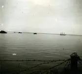 10 maj 1945. Vy över Kalmarsund. En landstigningsbåt syns i fjärran. Ombord är balter i tysk uniform och tyska soldater. De kom från det sista tyska brohuvudet i Kurland. Ungefär 3000 soldater flydde.  Ungefär hälften kom till Kalmar. Här internerades de i läger på Kullö innan de fördes över till Eksjö. En del av dem utlämnades sedan, i enlighet med stilleståndsavtalet, till Sovjet.