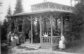 Stora paviljongen på Fridhem. Från vänster (Dalarna) trädgårdskulla, Ester Kempe, Einar Ödman, okänd, professorskan Jenny Ödman, f. Kempe. Fru Henrietta Kempe, Göta Fahleman (sedermera Hamberg), okänd, okänd, omkring 1880. 