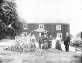 Grupporträtt framför byggnad, okänd ort.