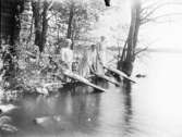 Grupporträtt, tre kvinnor som klappar tvätt i sjön.
