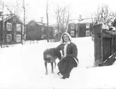 Porträtt, kvinna med hund i snön.