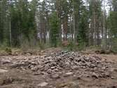 En förhistorisk grav, stensättning efter framrensning. I bakgrunden syns ytterligare en framrensad stensättning. 

Bilden är tagen i samband med en arkeologisk förundersökning utanför Mullsjö, Jönköpings län.