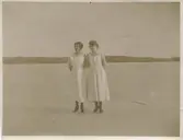 Två arbetskamrater står på Tulebosjön vintern 1920. Från vänster: Clary samt Hilda Olsson (1887-1973, 1923 gift Sandberg). Kvinnorna arbetade som husor hos Håkan Jönsson som var rektor på Stretereds skolhem. Bildtext från album 