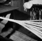 Närbild av tillverkning av bögsäcksfässlor, flätning, slingning, i Gruddbo by.