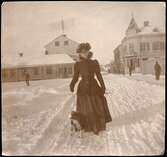Vintermotiv kvinna med hund, Torggatan vid Stora torget, Enköping, vy från sydöst, 1892-1902.