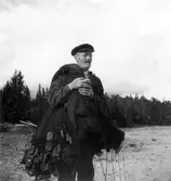 Gustaf Norell, fiskare och torpare i Solumsbyn bär ut sina skötar för att fiska strömming i Sjövikens vatten. Även hans söner Verner och Helge kom att utöva samma yrke under första delen av sin levnadstid.