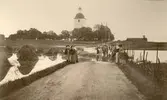 Lokalbefolkning vid översvämmad väg i Stora Mellösa, 1910-08-03