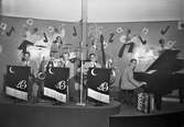 Orkestern Moon band spelar i Nöjesparken i september 1943. Första bilden visar sexmannabandet på scen och på bild 2 står de samlade nedanför scenen. De har med en nalle som mascot. På väggen en målad dekor med noter och musiker. (Se även bild GB2_4017)