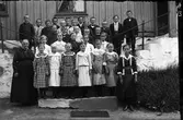 Lärarinnan Constance Engström med finklädda elever på trapporna till Sällstorps första skolhus i Lugnet. Fotografiet bedöms vara taget omkring år 1914. Constance var folkskollärare i socknen åren 1891-1921. Pojke nr 2 från vänster heter Ragnar Börjesson, Karlsberg, och förmodligen är flickorna ytterst på rad två från Hansa; Hilma J längst till vänster och Gerda J längst till höger.
