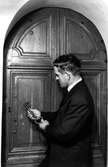 Detalj av sakristiadörr och nyckel. Personen på bilden är kyrkvaktmästare Edvard Engström.