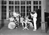 Jazzorkester med ynglingar som spelar i en lokal med stora spröjsade fönster (Societeten). Från vänster: trummor Evert Nilsson, banjo Valter Nilsson 