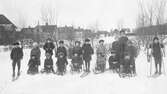 Barn med skidor och kälke vid fotbollsplan vid Kumlins väg, 1910-tal