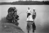 Familj på utflykt med metspö och segelbåt, 1930-tal