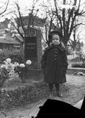 Flicka vid familjegrav på Södra kyrkogården, 1920-tal